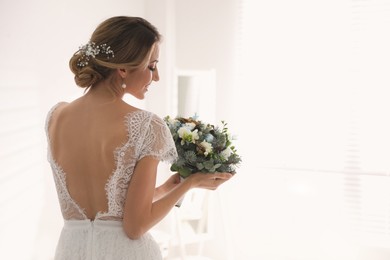 Photo of Beautiful bride with winter wedding bouquet indoors. Space for text