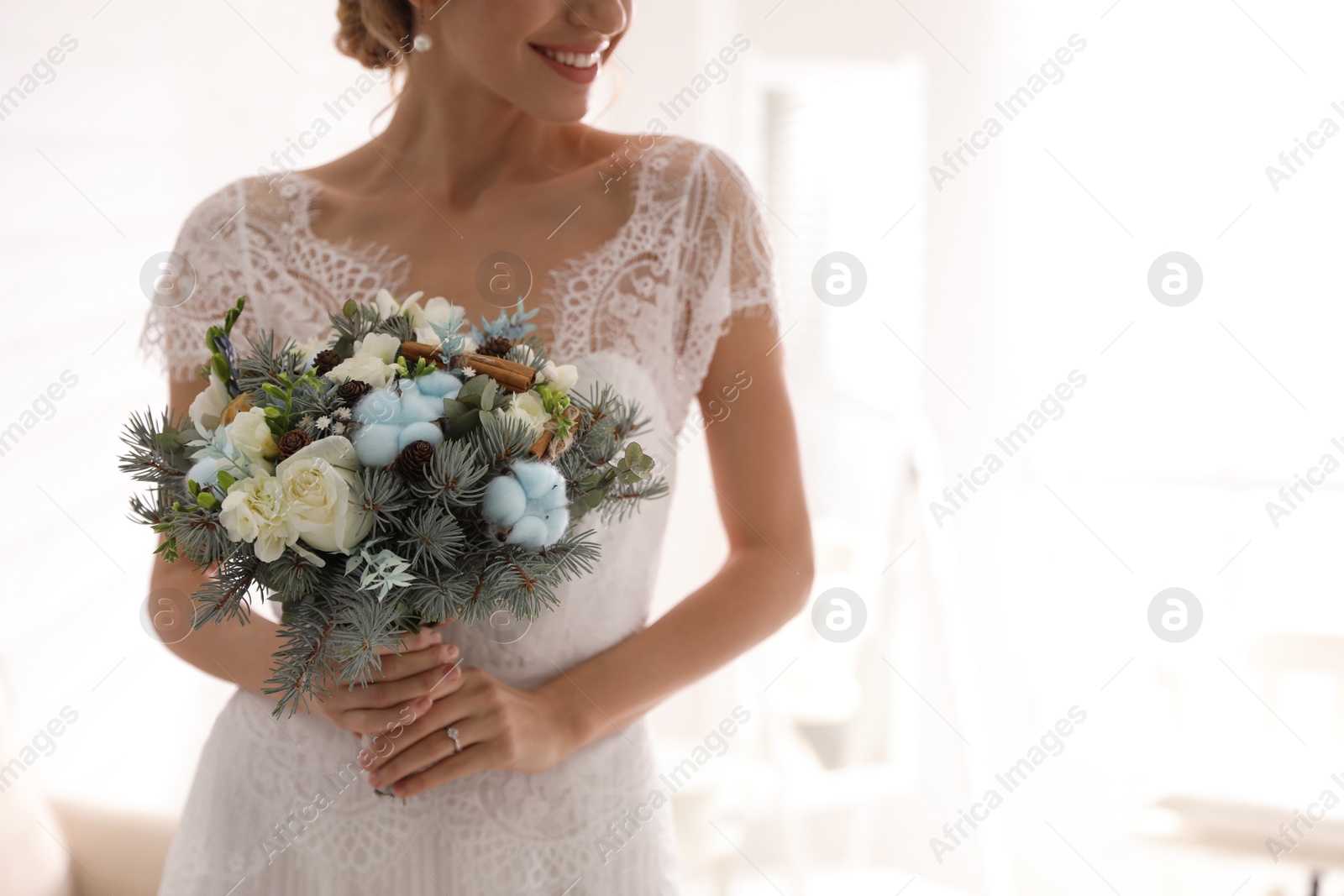 Photo of Beautiful bride with winter wedding bouquet indoors, closeup. Space for text