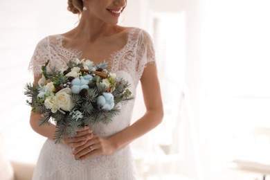 Photo of Beautiful bride with winter wedding bouquet indoors, closeup. Space for text