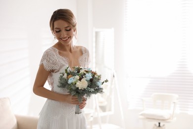 Beautiful bride with winter wedding bouquet indoors. Space for text