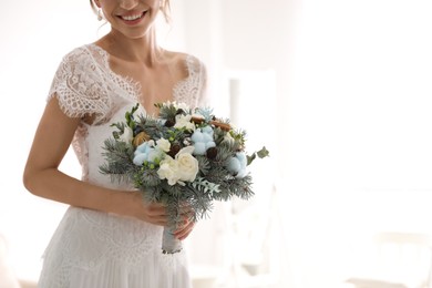 Beautiful bride with winter wedding bouquet indoors, closeup. Space for text