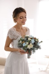 Beautiful bride with winter wedding bouquet indoors