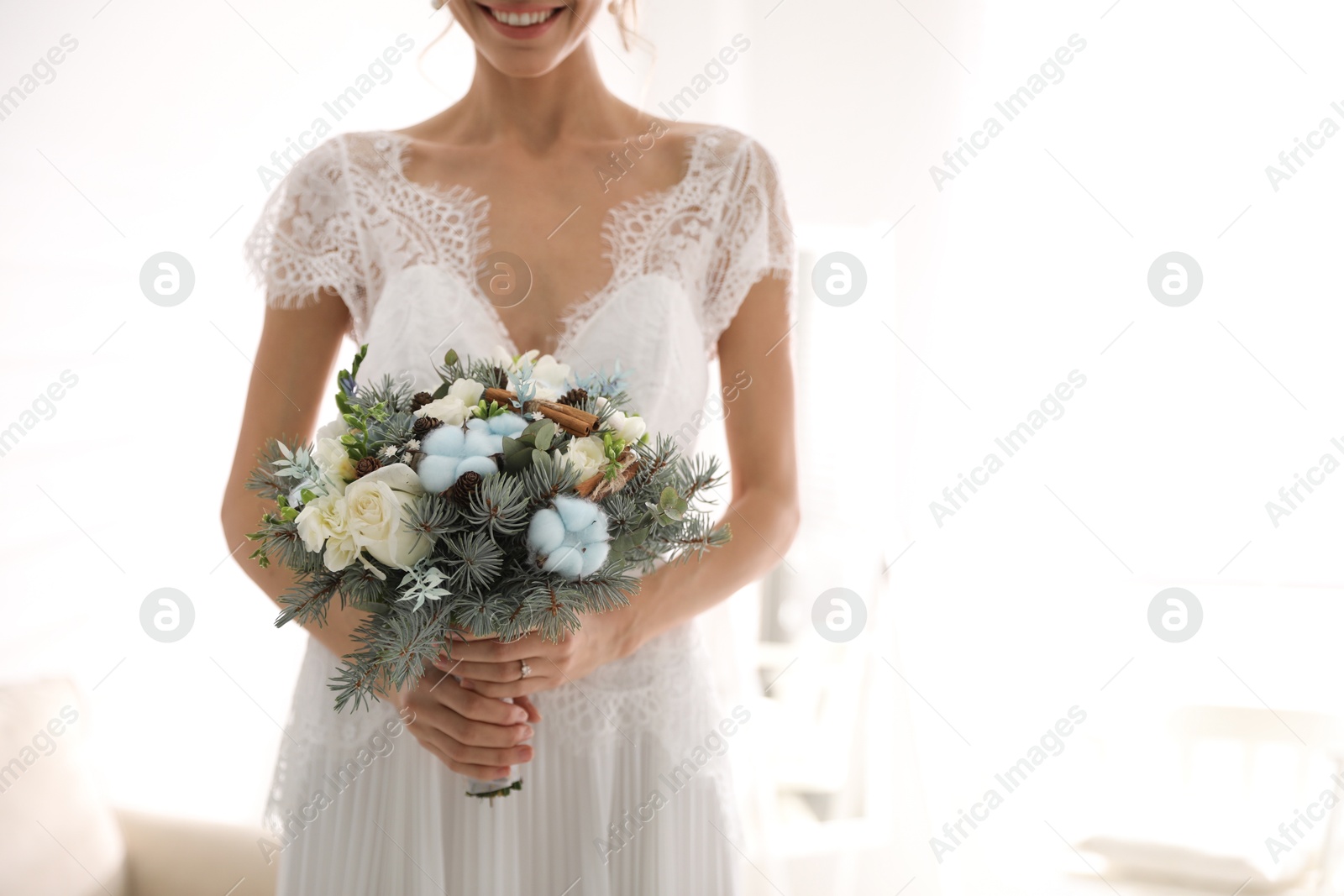 Photo of Beautiful bride with winter wedding bouquet indoors, closeup. Space for text