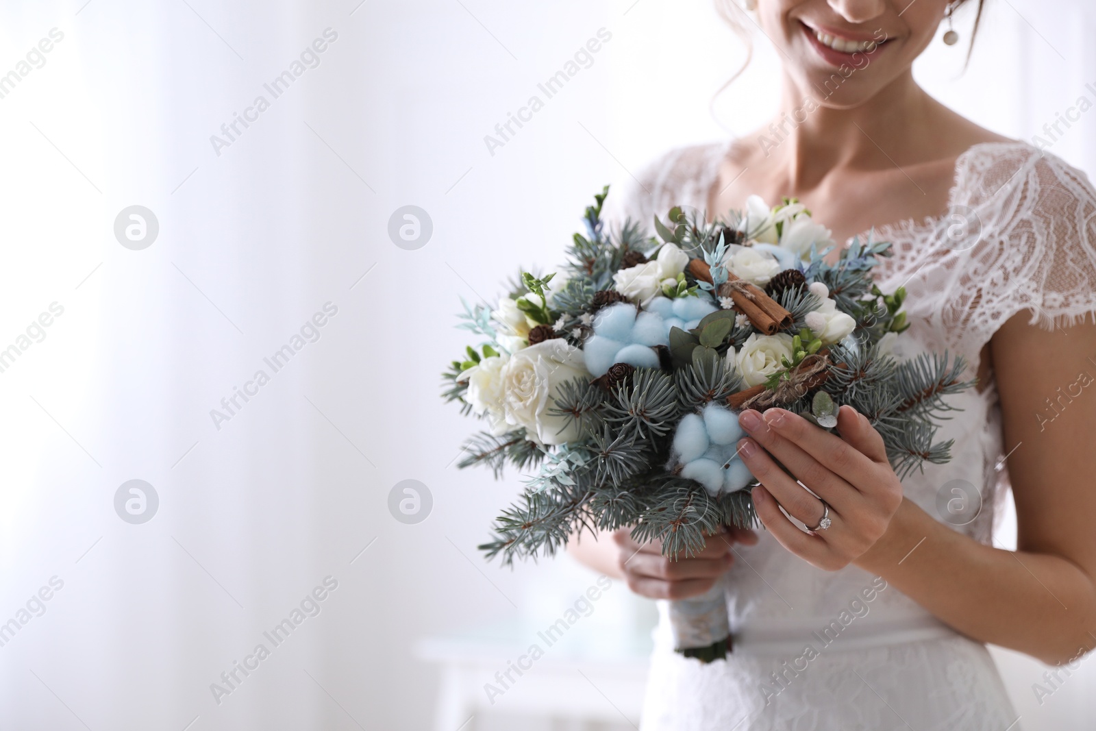 Photo of Beautiful bride with winter wedding bouquet indoors, closeup. Space for text