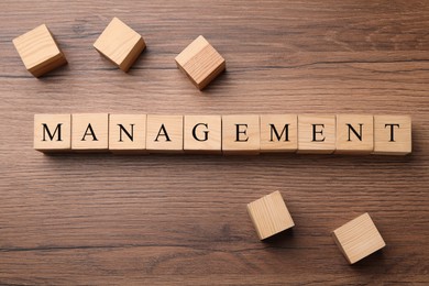 Photo of Word Management made of wooden cubes on table, flat lay