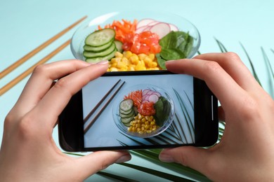 Blogger taking photo of lunch on turquoise background, closeup