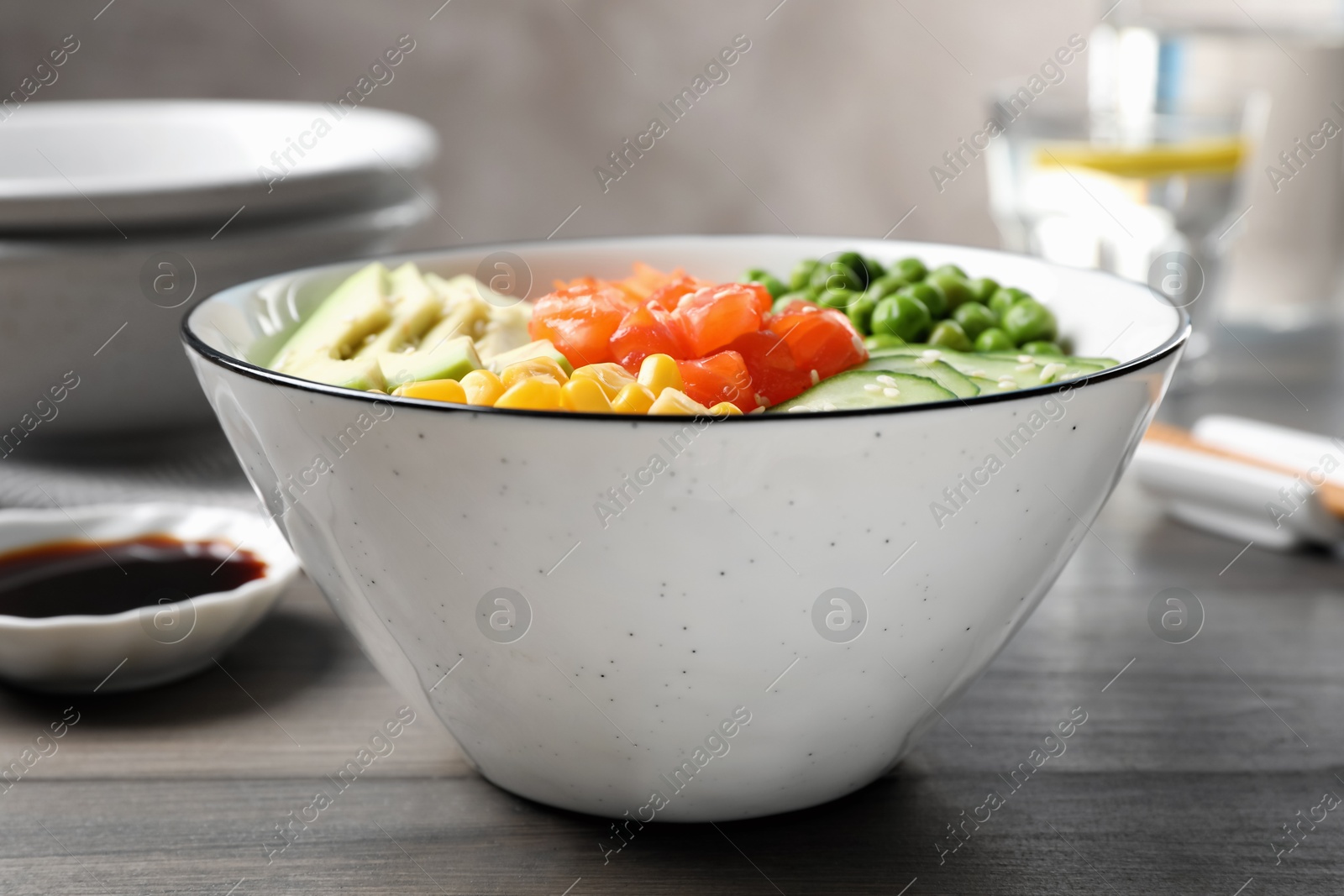 Photo of Delicious salad with salmon and vegetables on wooden table, closeup