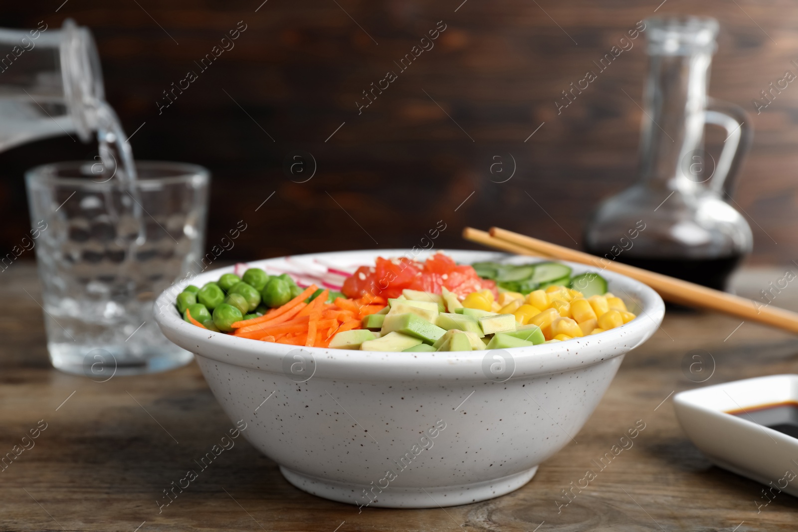 Photo of Delicious salad with salmon and vegetables on wooden table