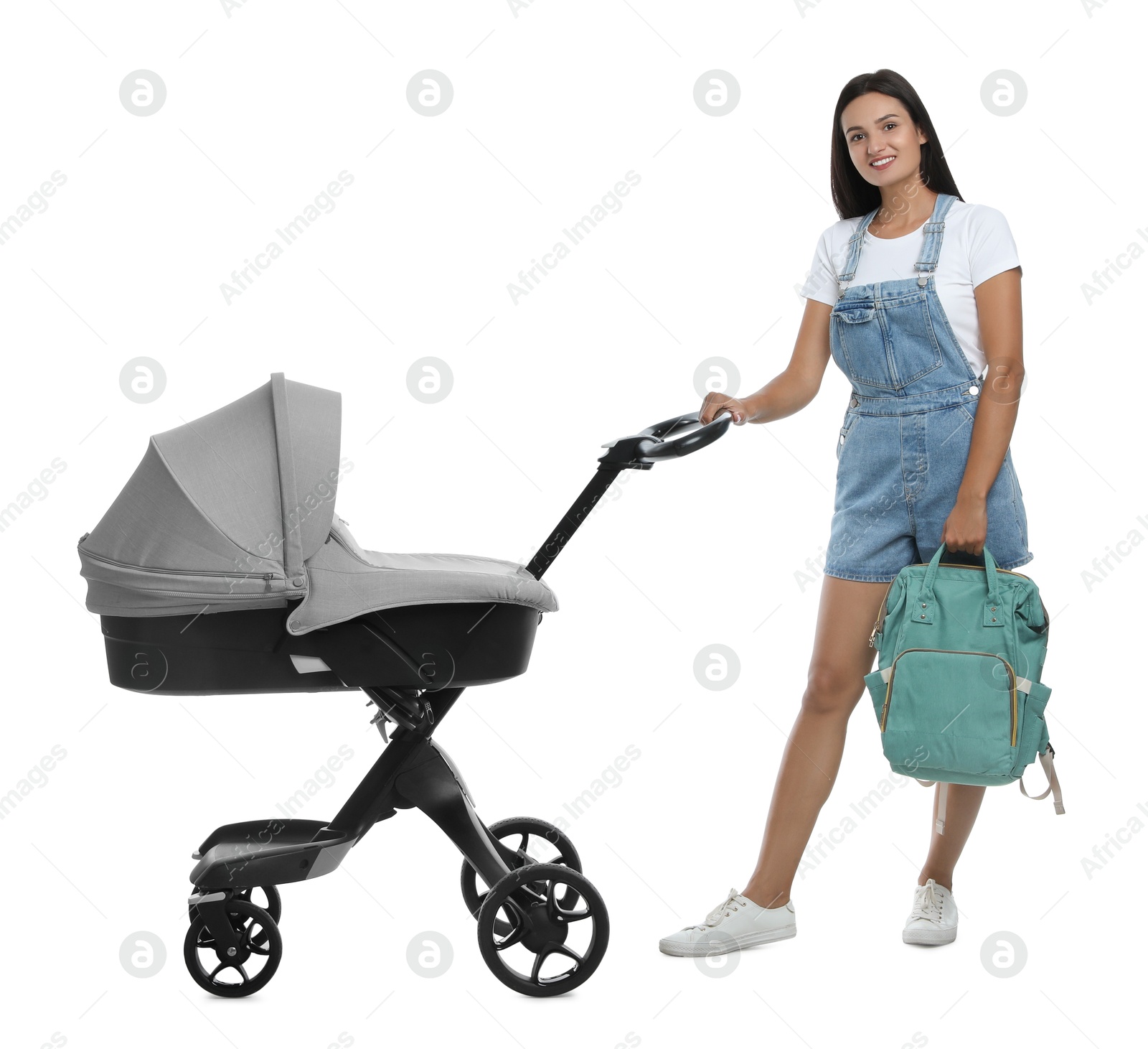 Photo of Happy young woman with baby stroller on white background