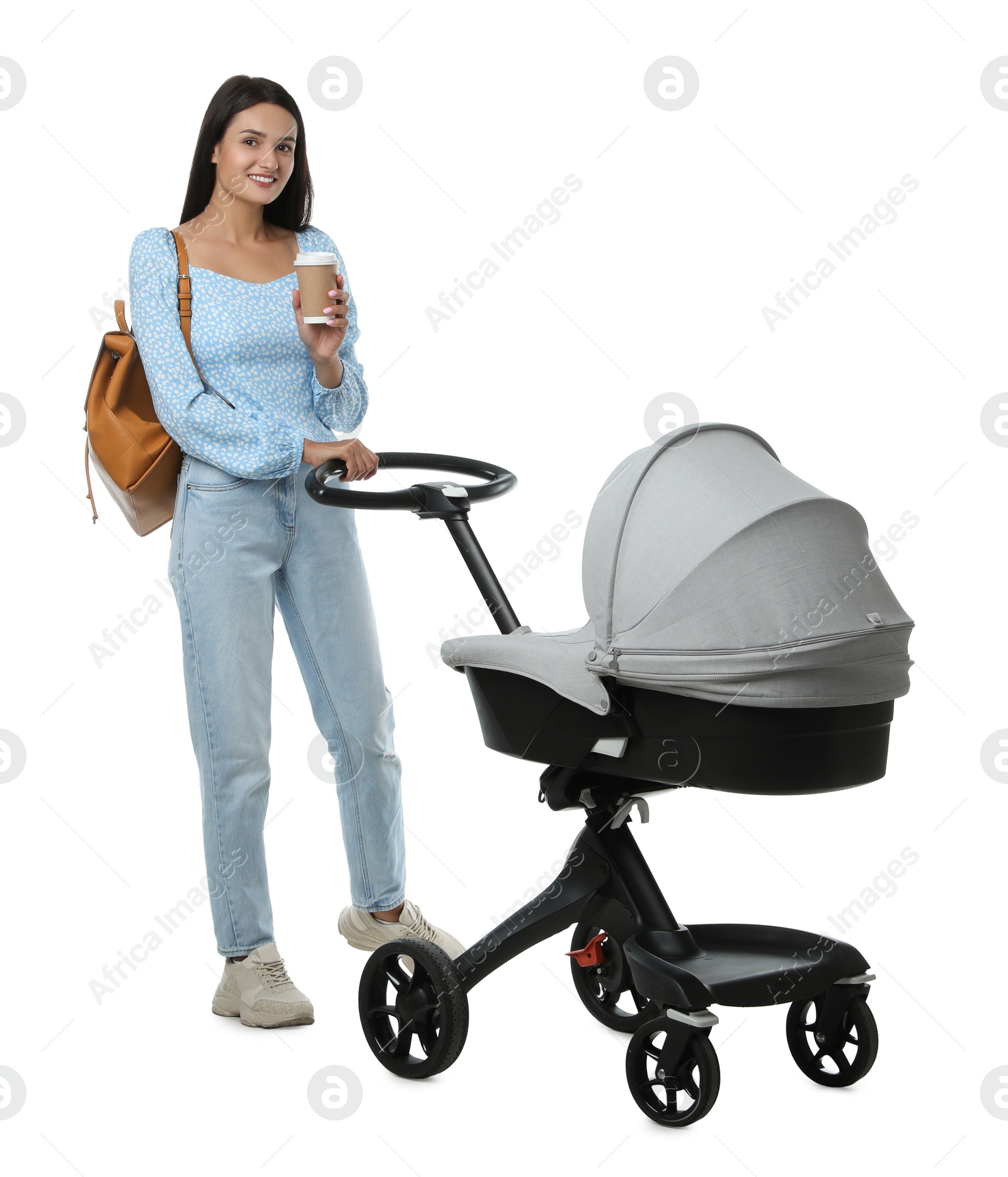 Photo of Happy young woman with cup of drink and baby stroller on white background