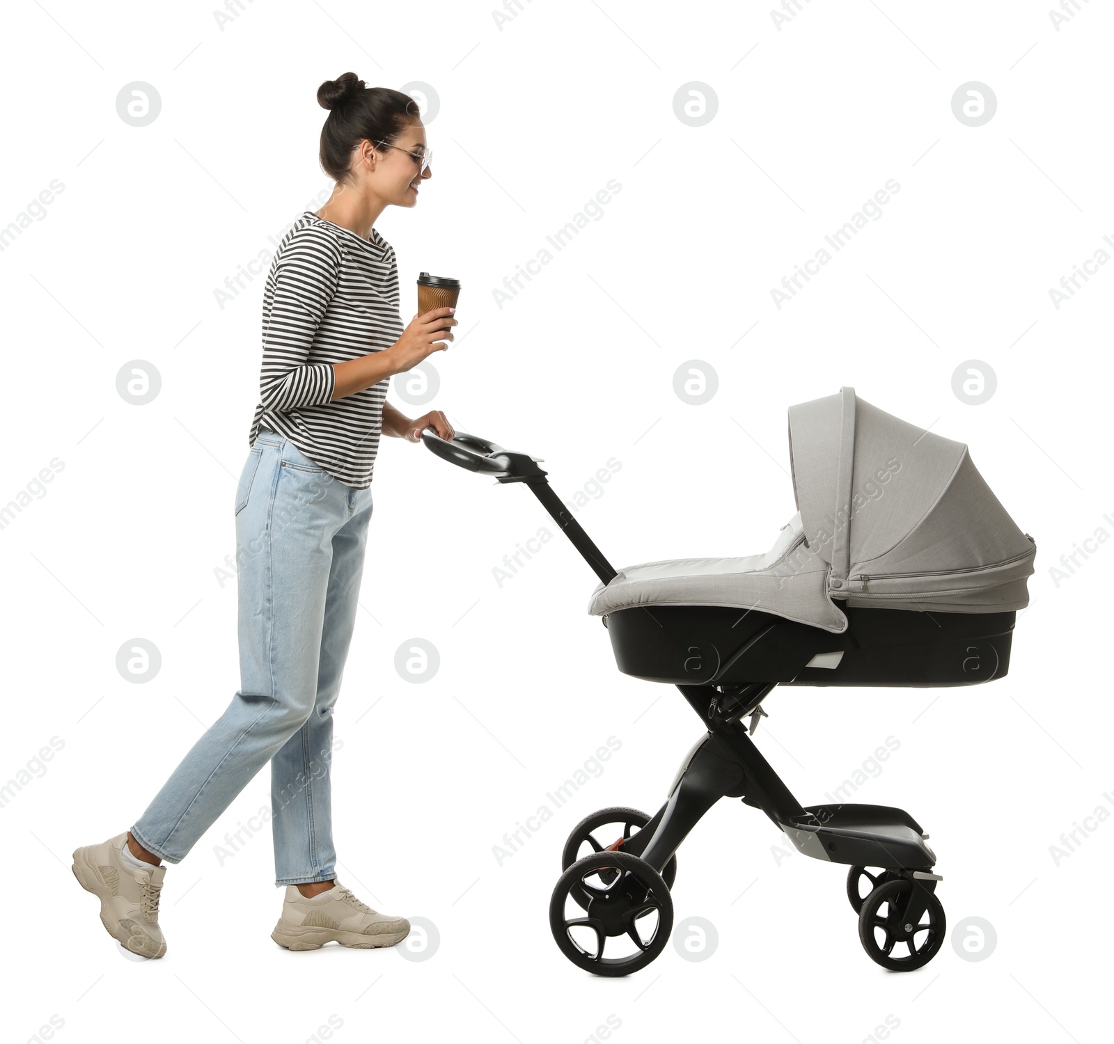 Photo of Happy young woman with cup of drink and baby stroller on white background