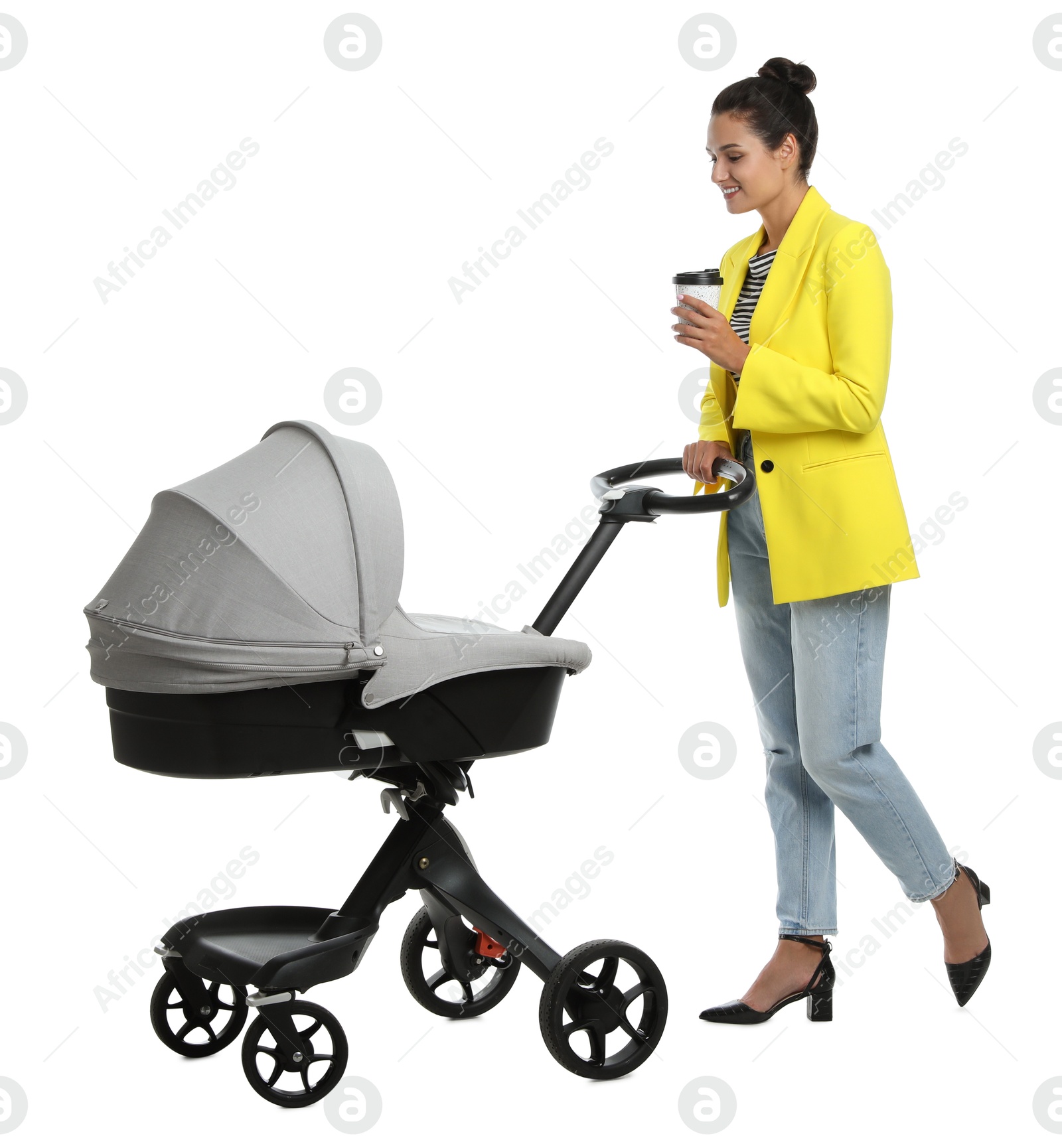 Photo of Happy young woman with cup of drink and baby stroller on white background