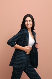 Photo of Beautiful woman in formal suit on pale pink background. Business attire