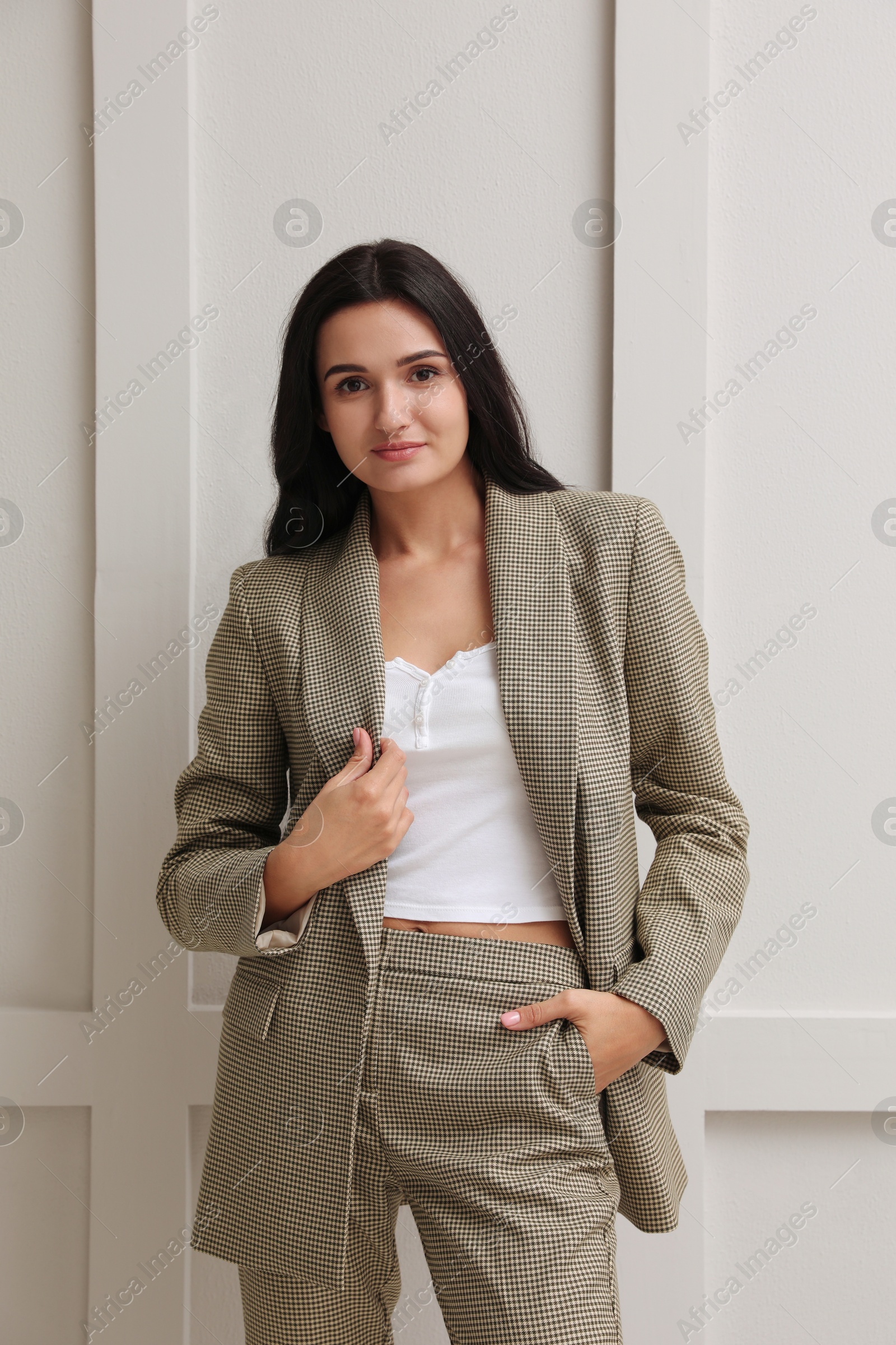 Photo of Beautiful woman in formal suit near light grey wall. Business attire