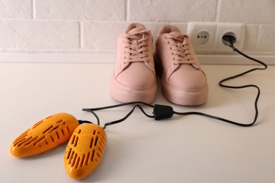 Shoes and electric dryer on floor indoors