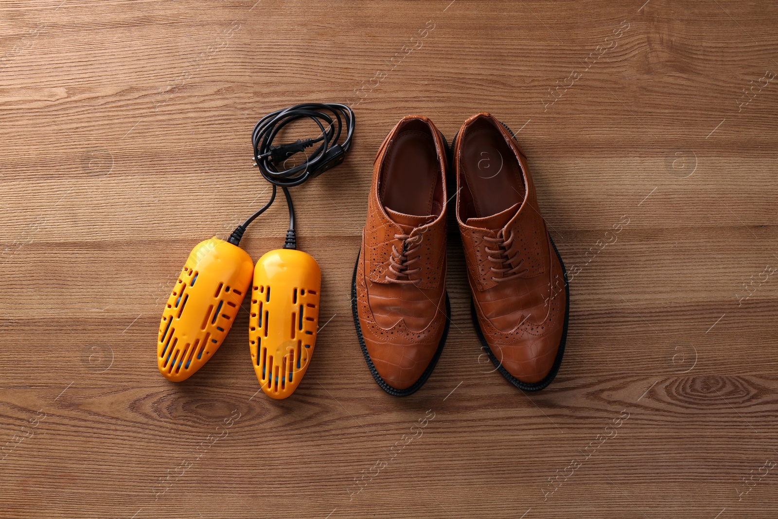 Photo of Shoes and electric dryer on wooden background, flat lay