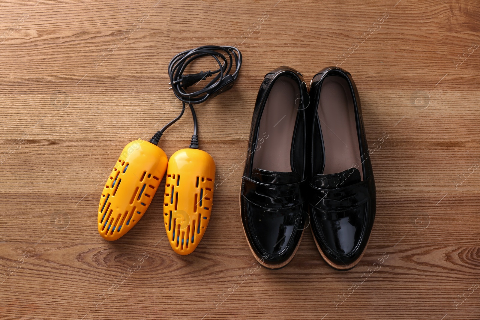 Photo of Shoes and electric dryer on wooden background, flat lay