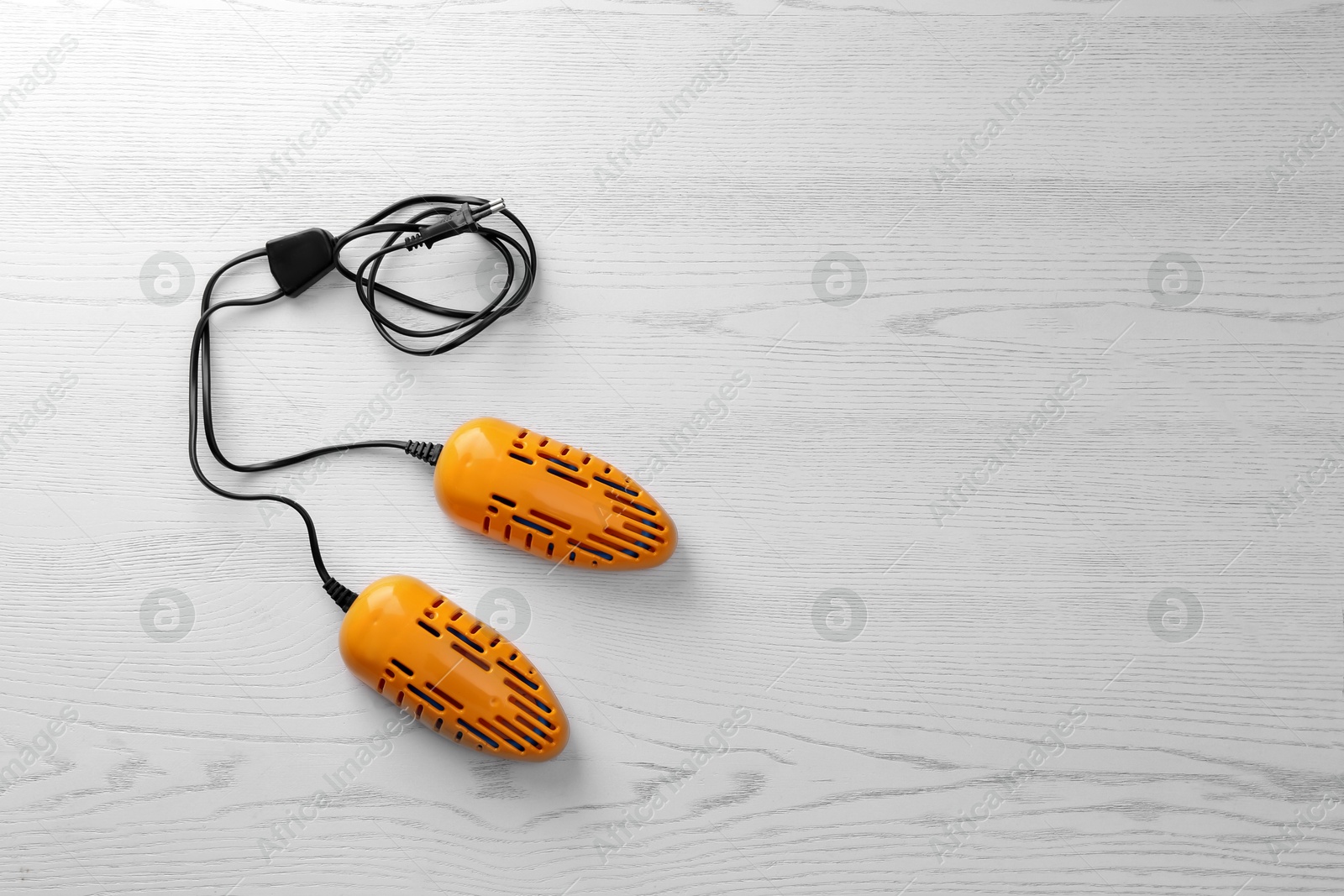 Photo of Electric shoe dryer on white wooden background, top view. Space for text