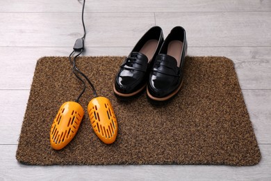 Shoes and electric dryer on rug indoors