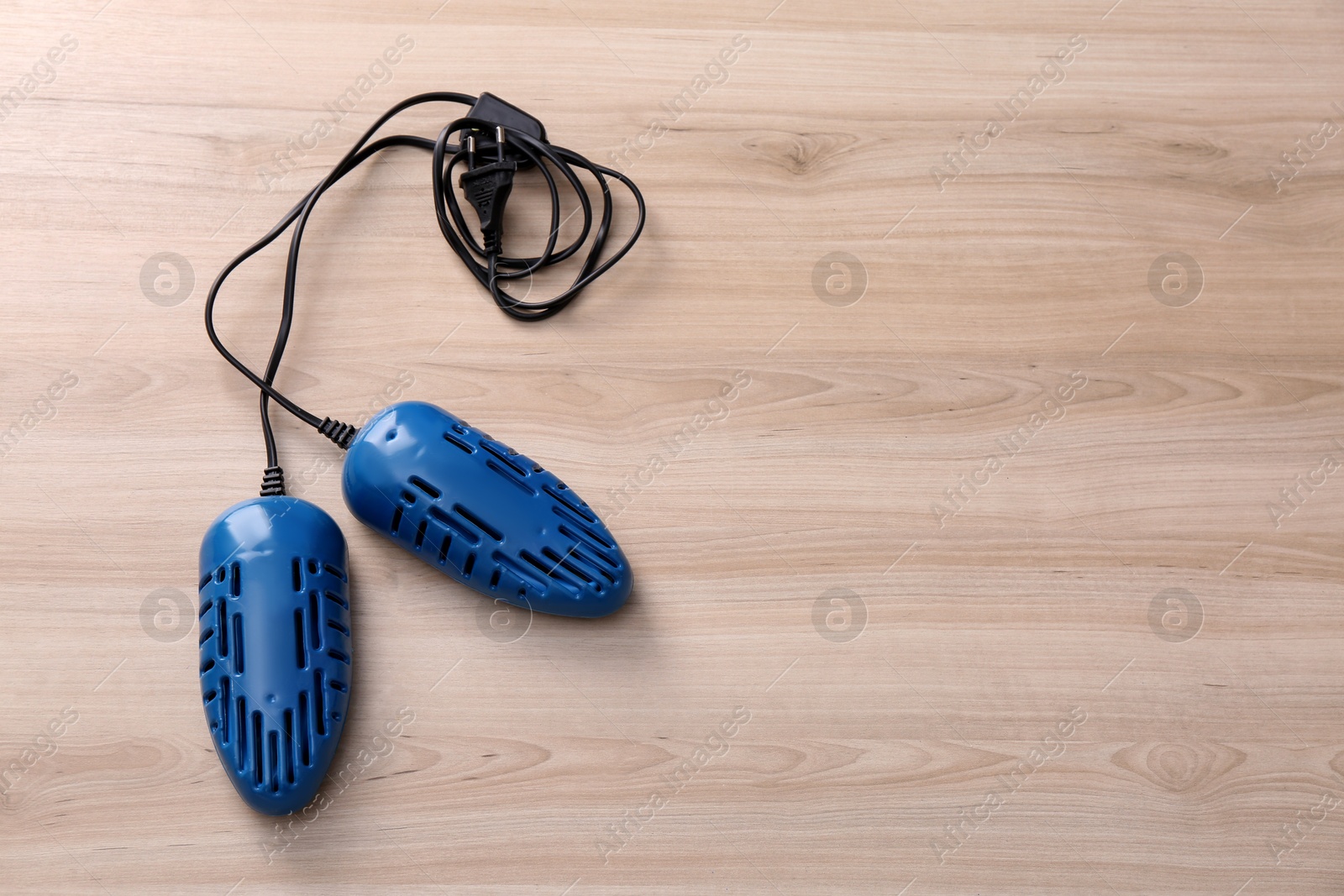 Photo of Electric shoe dryer on wooden background, top view. Space for text