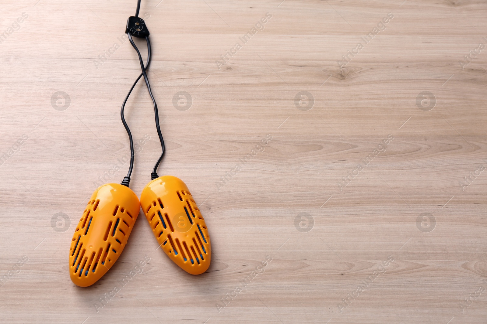 Photo of Electric shoe dryer on wooden background, top view. Space for text