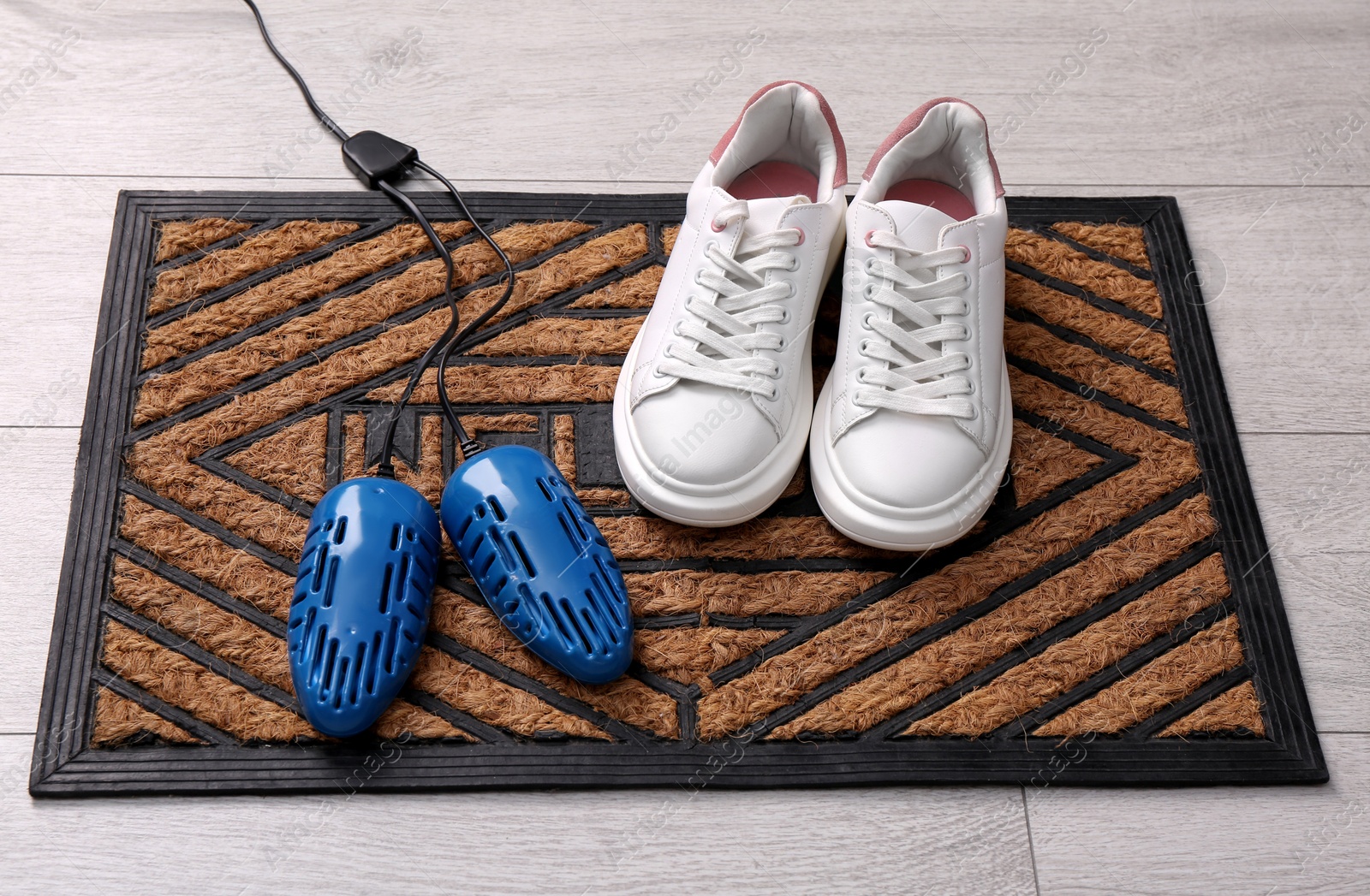 Photo of Shoes and electric dryer on rug indoors