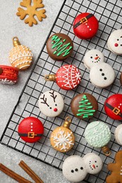 Photo of Beautifully decorated Christmas macarons and cinnamon on light grey table, flat lay