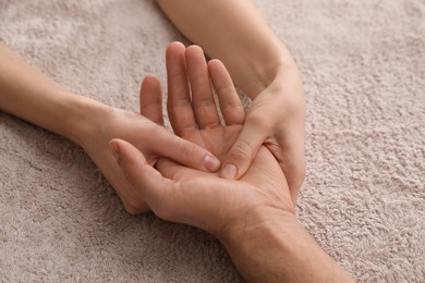 Photo of Man receiving hand massage on soft towel, closeup