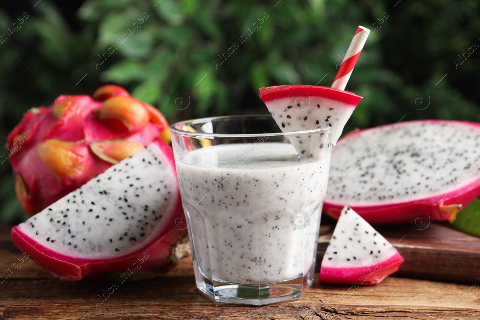 Photo of Delicious pitahaya smoothie and fresh fruits on wooden table