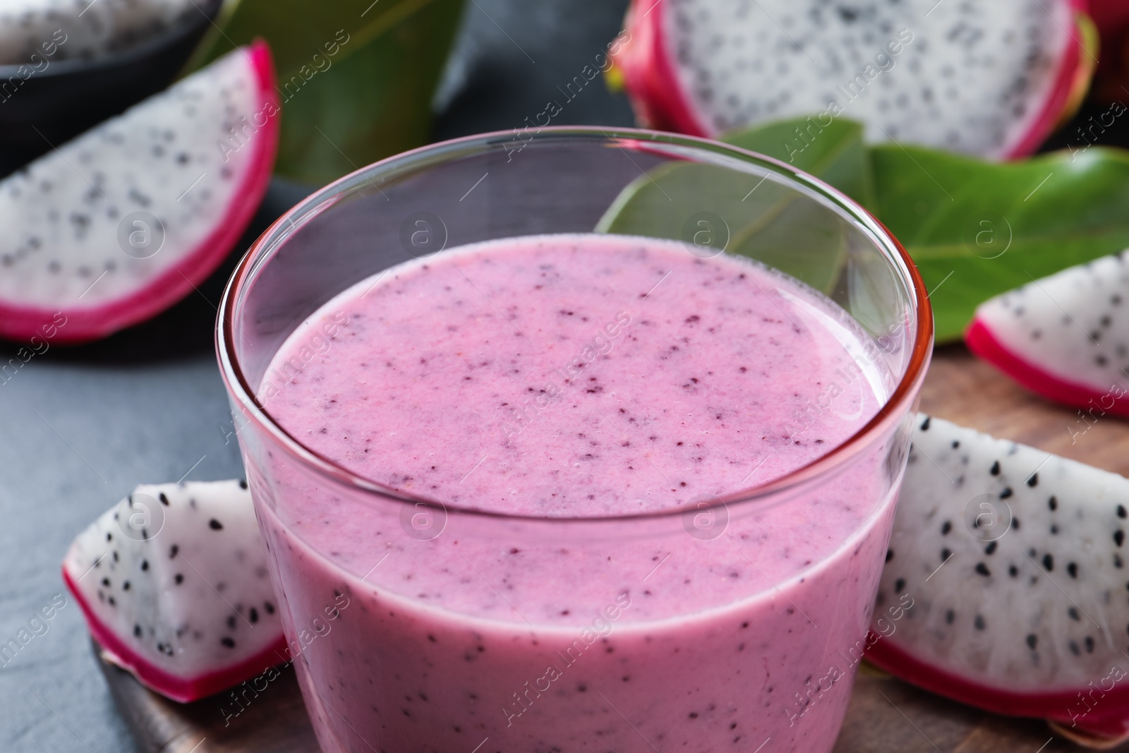 Photo of Delicious pitahaya smoothie and fresh fruits on table, closeup