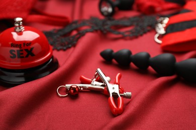 Photo of Sex toys and accessories on red fabric