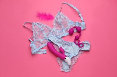 Photo of Sex toys, feather and lingerie on pink background, flat lay