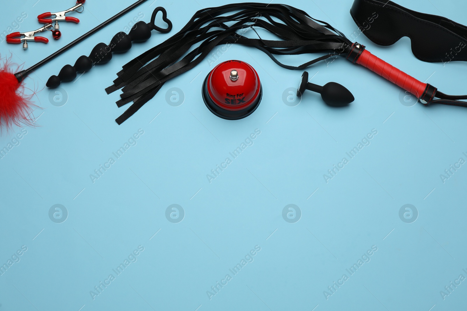 Photo of Sex toys and accessories on light blue background, flat lay. Space for text