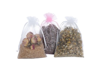 Photo of Scented sachets with dried flowers on white background
