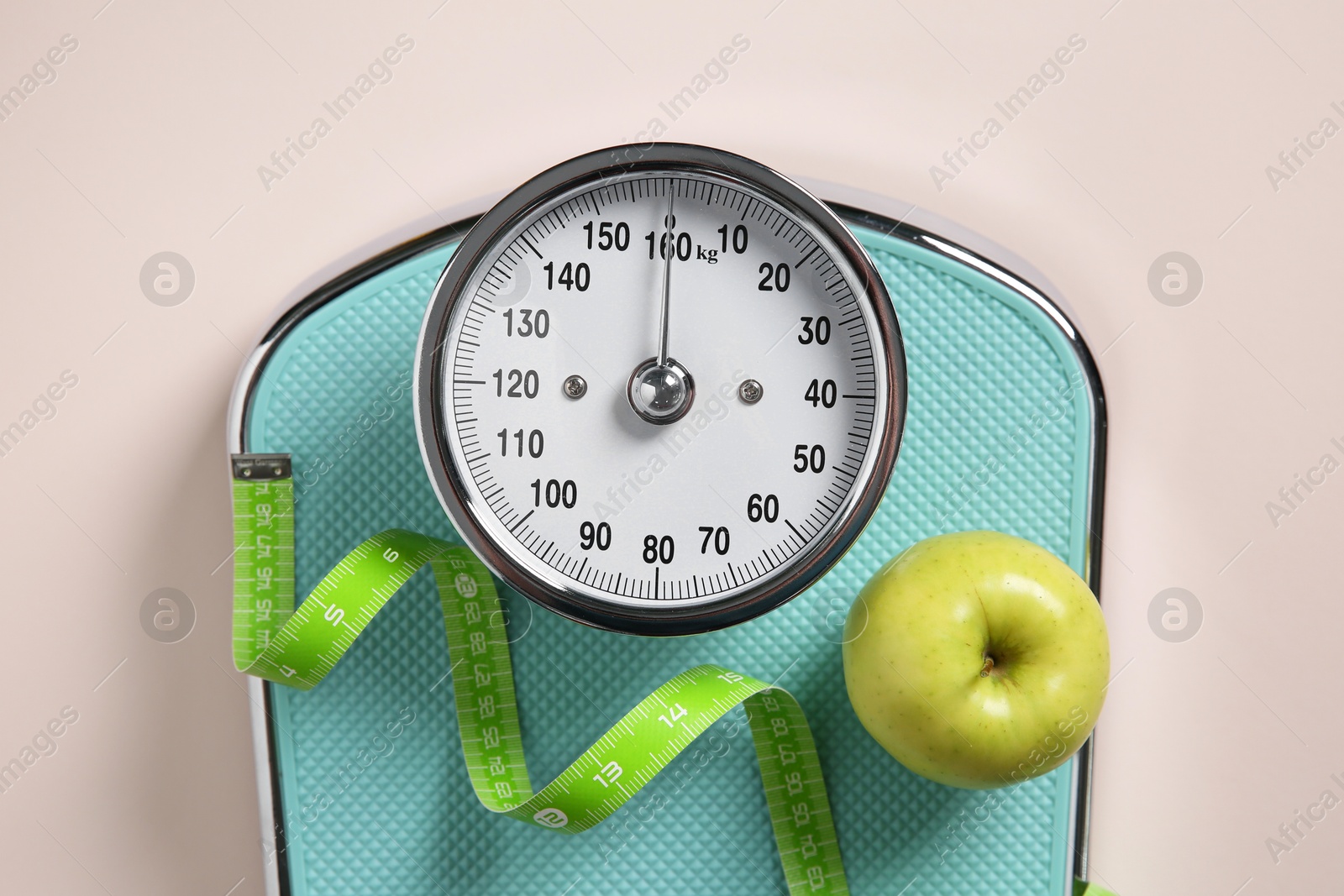 Photo of Scale, measuring tape and fresh apple on beige background, top view