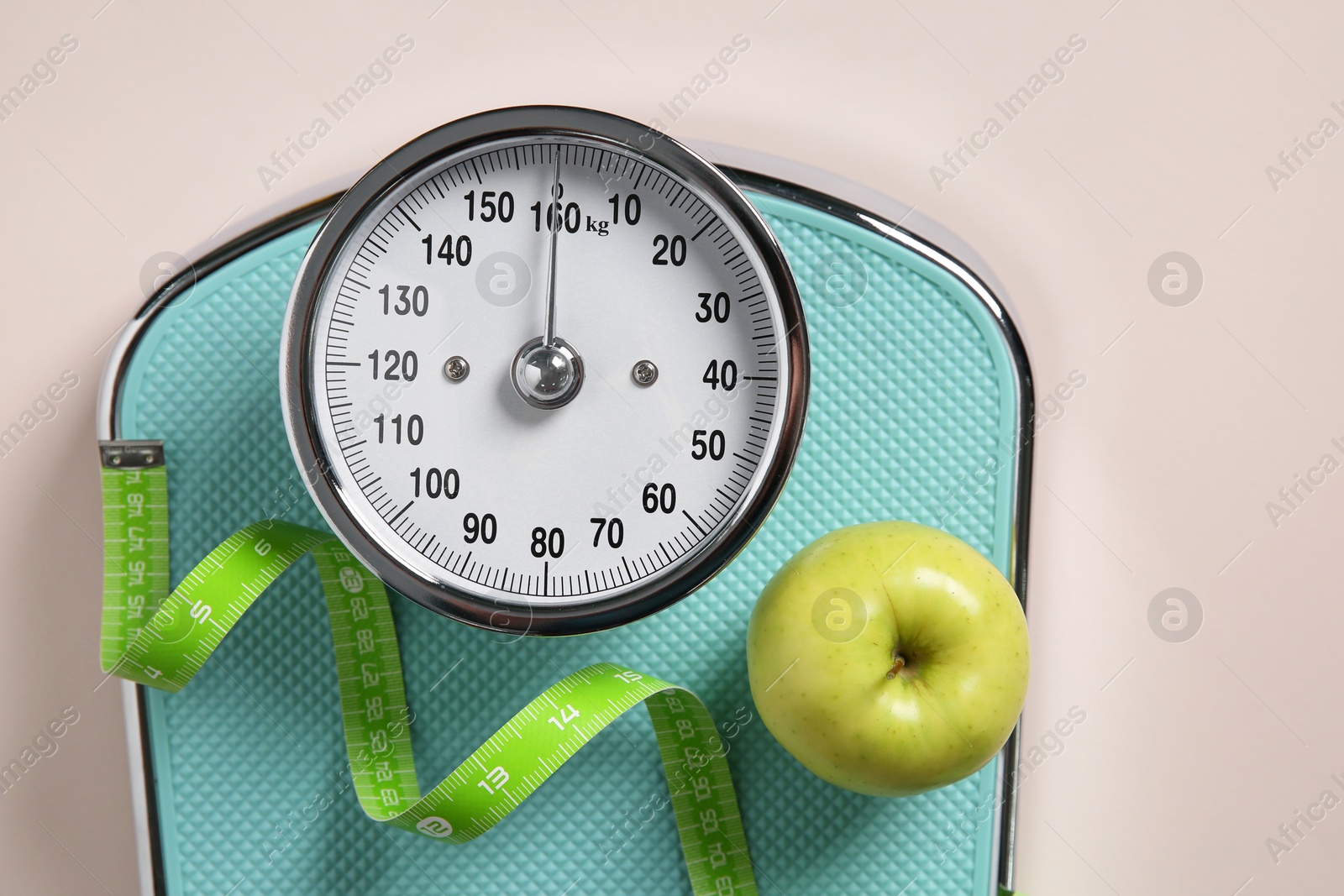 Photo of Scale, measuring tape and fresh apple on beige background, top view