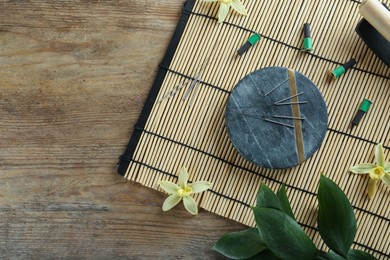 Photo of Flat lay composition with acupuncture needles on wooden table. Space for text