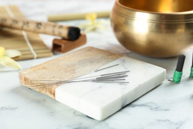 Photo of Coaster with acupuncture needles on white marble table