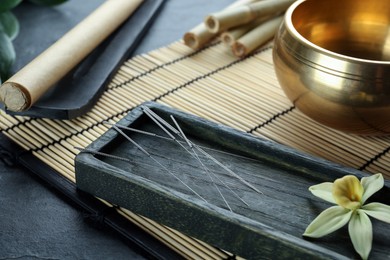 Photo of Composition with acupuncture needles on black table