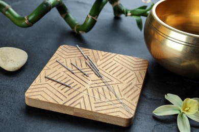 Photo of Composition with acupuncture needles on black table