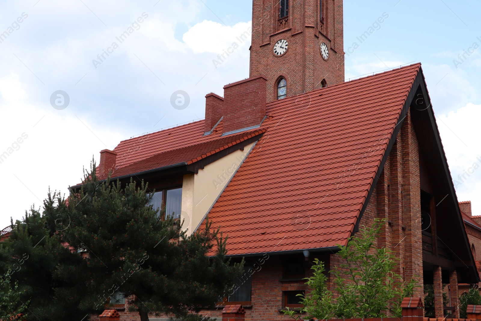 Photo of View of beautiful house with brown roof against blue sky