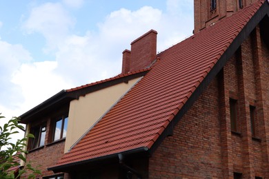 View of beautiful house with brown roof against blue sky