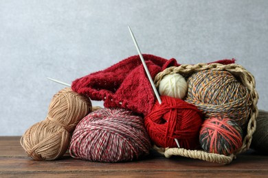 Soft woolen yarns, knitting and needles on wooden table