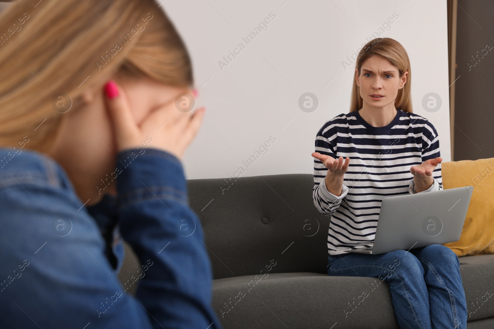 Photo of Teenage daughter crying while mother scolding her at home