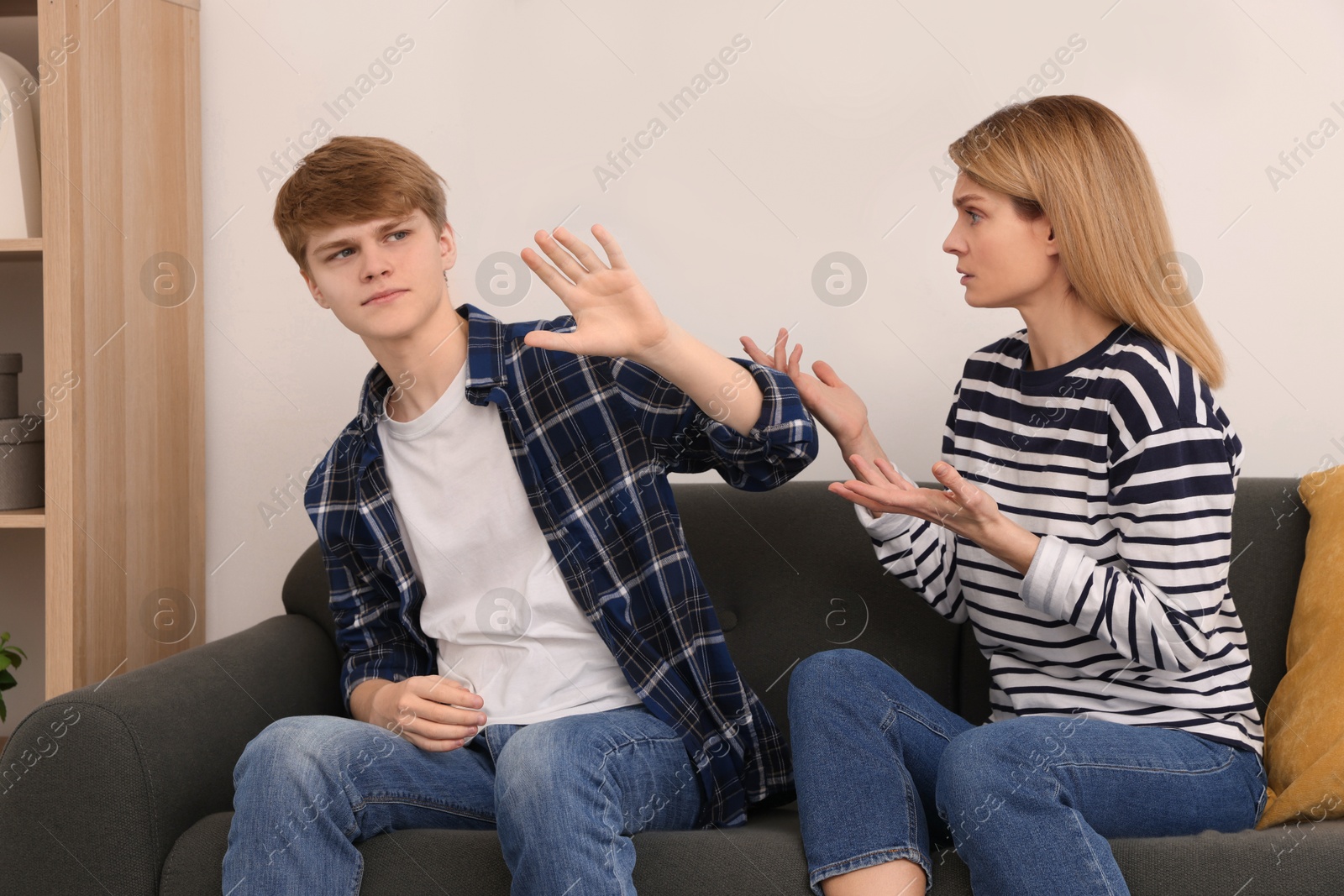 Photo of Mother and her teenage son having argument at home