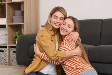 Photo of Happy mother hugging her teenage daughter at home