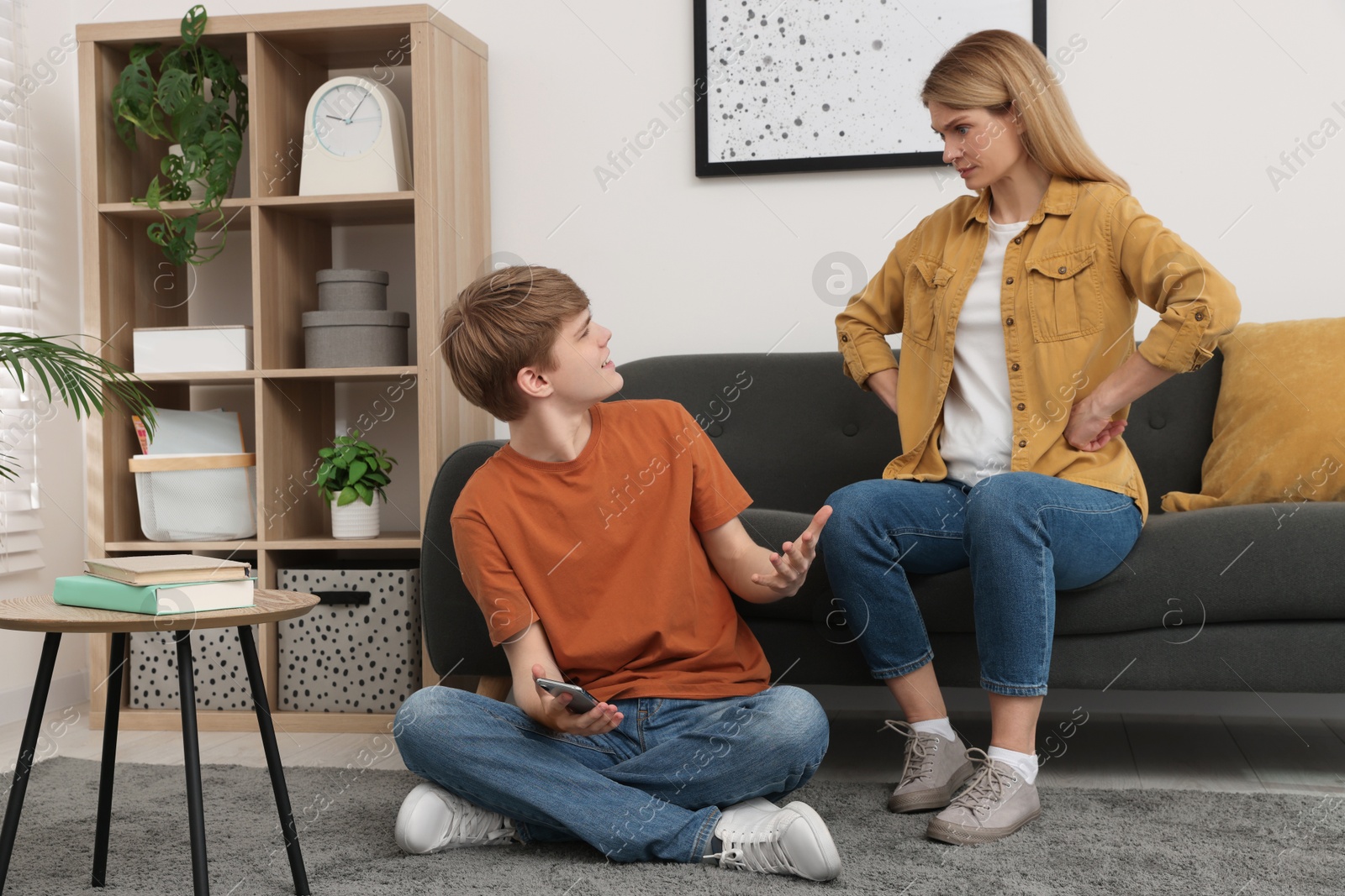 Photo of Mother and her teenage son having argument at home