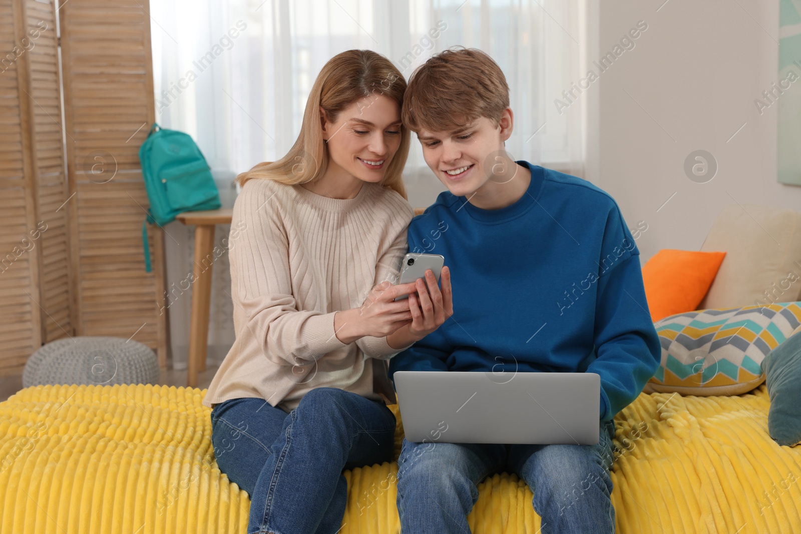Photo of Happy mother and her teenage son spending time together at home