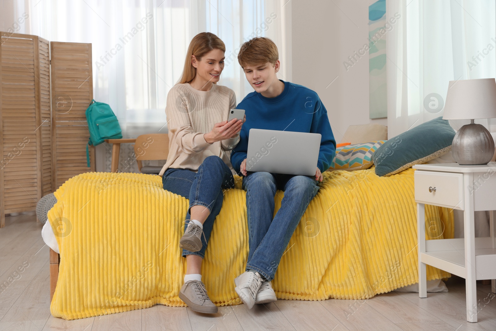 Photo of Happy mother and her teenage son spending time together at home