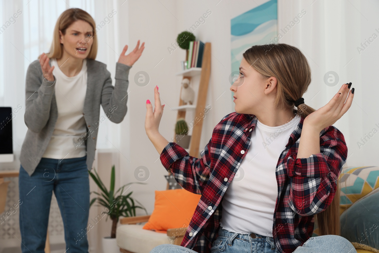 Photo of Mother scolding her teenage daughter at home